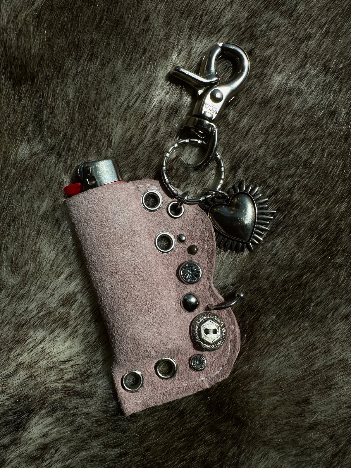 Pink leather lighter case with mixed silver hardware and a heart charm.